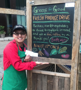 Student in front of chalk board at farmers market